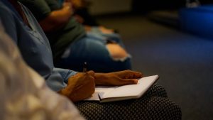 person holding pen and white paper on person lap