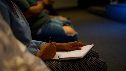 person holding pen and white paper on person lap