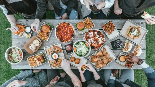 a group of people sitting around a table with food